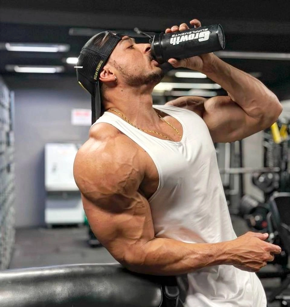 Atleta Felipe Franco, Men’s Physique PRO, bebendo um shake dentro de uma academia