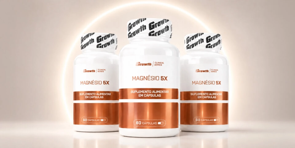 IMAGEM ILUSTRATIVA - Magnésio 5X Growth Supplements em cima da mesa ao lado de um copo de água e um computador